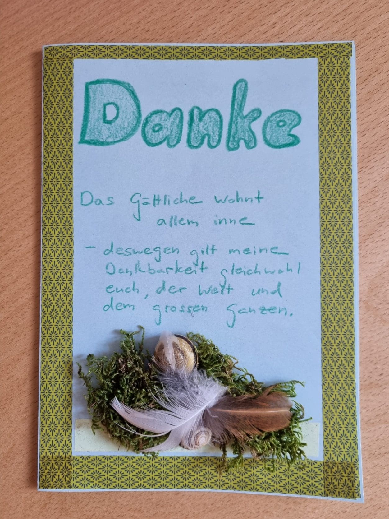 handgeschriebene Karte mit Moos und Federn verziert